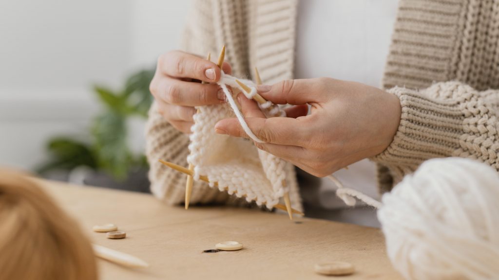close-up-hands-knitting-with-white-yarn
